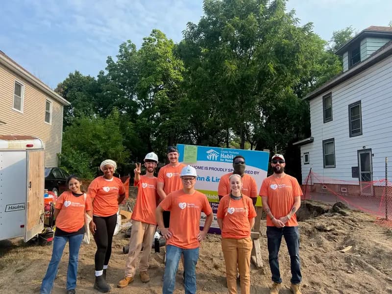 Qualitrol volunteer team in orange shirts at Habitat for Humanity construction site